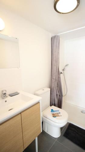 une salle de bain avec des toilettes blanches et un lavabo dans l'établissement Le Clos des Flots - L'Océan, à La Flotte