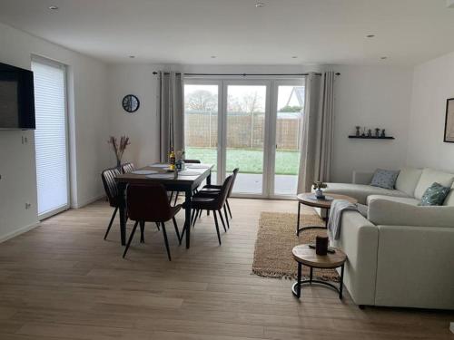 a living room with a table and chairs and a couch at Beautiful modern country home in Wegberg
