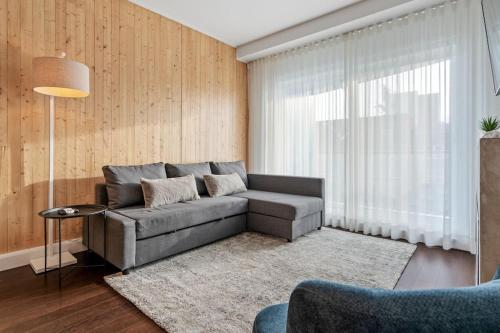 Initial / Saphir / Québec في مدينة كيبك: غرفة معيشة مع أريكة رمادية وسجادة