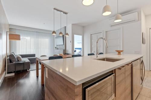 a kitchen with a sink and a living room at Initial / Saphir / Québec in Quebec City