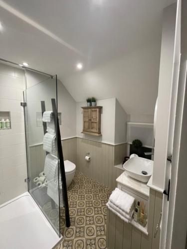 La salle de bains est pourvue d'une douche, de toilettes et d'un lavabo. dans l'établissement BEECH COTTAGE, à Hatherop