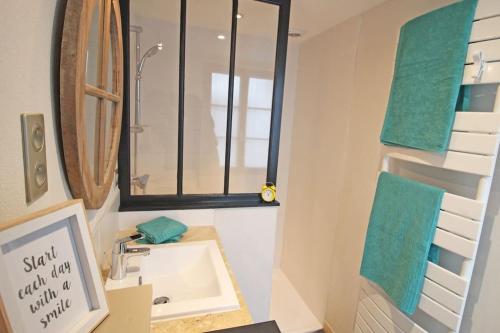 une salle de bain avec un lavabo, un miroir et une fenêtre dans l'établissement La Villa des Flots, à La Flotte