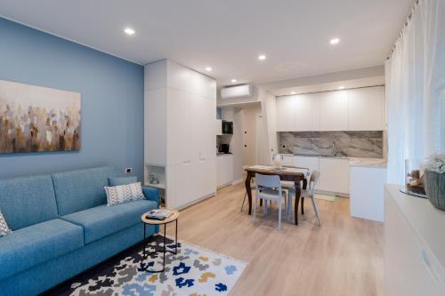 uma sala de estar com um sofá azul e uma mesa em Ariston & Casinò - Appartamento con Giardino e Garage em Sanremo