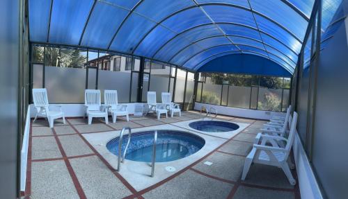a patio with a hot tub in a building with a blue ceiling at Feliz Amanecer in Sáchica