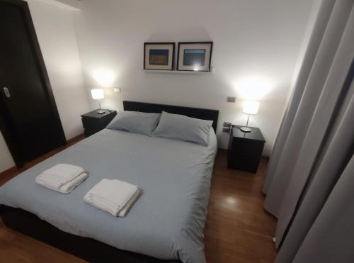 um quarto com uma cama branca com duas toalhas em Casa di Roby em Bari