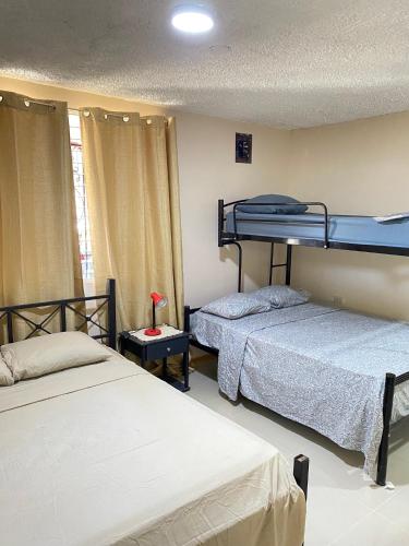 a bedroom with two bunk beds and a window at Agutí Apartment in Manuel Antonio