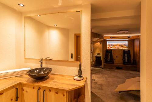 y baño con lavabo en un mostrador de madera. en Hotel Garni Försterheim, en Ischgl