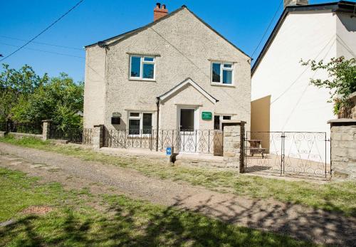 a house with a fence in front of it at Hazeldene Cottage in Parkend