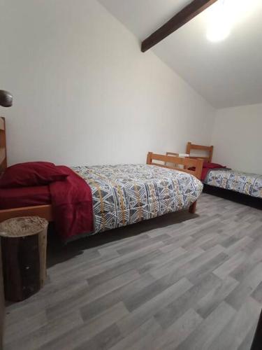a bedroom with two beds and a wooden floor at Cabaña en playa San Ignacio in Valdivia