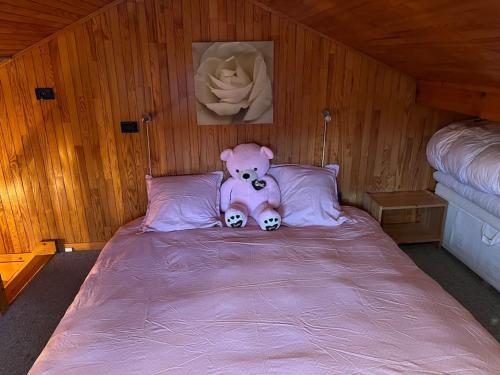 a pink teddy bear sitting on top of a bed at Chalet Cosy Les Gets Vue Montagne in Les Gets