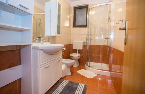 a bathroom with a sink and a shower and a toilet at Apartment Ivan 2 in Funtana