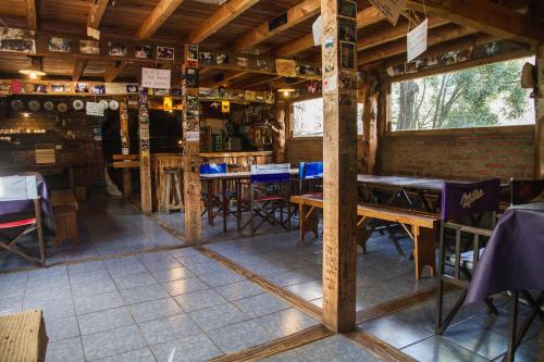una habitación con mesas y sillas en un edificio en Hostel Los Coihues en San Carlos de Bariloche