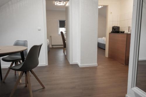 a room with a table and chairs and a kitchen at Hotel Teatro in Kassel