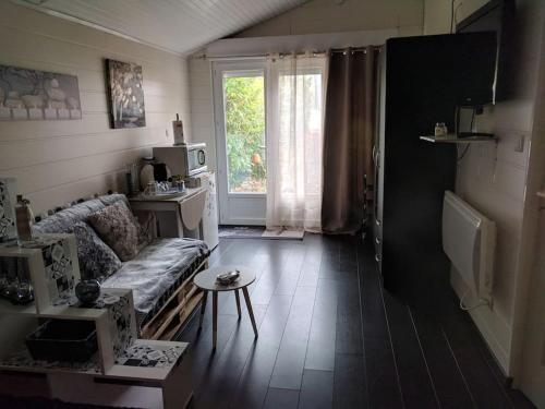 ein Wohnzimmer mit einer Couch und einem Fenster in der Unterkunft JOLI STUDIO PRIVE in Mont-de-Marsan