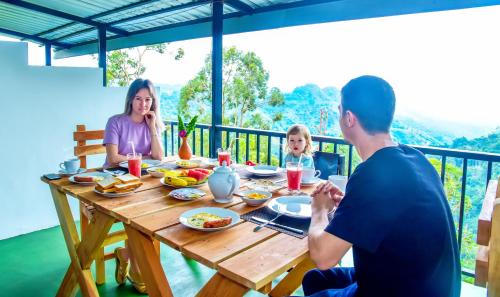 una familia sentada alrededor de una mesa de madera comiendo comida en Onestar Ella en Ella