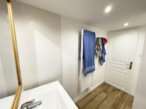 een badkamer met een witte wastafel en een deur bij L'appart' des Moussaillons in La Flotte