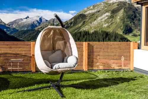 un columpio sentado en el césped con montañas en Haus Schrofenwies, en Lechleiten
