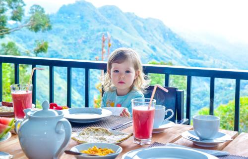 una bambina seduta a un tavolo con del cibo di Onestar Ella a Ella