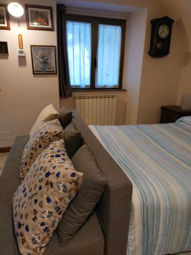 1 dormitorio con cama con almohadas y reloj en Casa sul Dosso, en Clusone