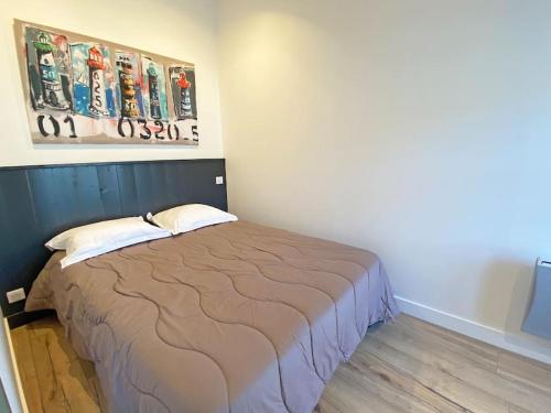 une chambre avec un lit et un tableau au mur dans l'établissement L'appart' Le Bois Flotté, au Bois-Plage-en-Ré