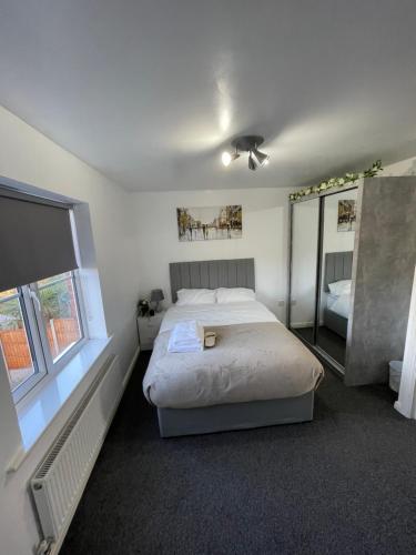 a bedroom with a bed and a large window at Hensh Homes in Saint Helens