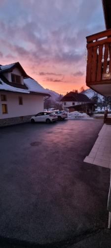 a parking lot with cars parked in front of a building at Apartma Lip in Rateče
