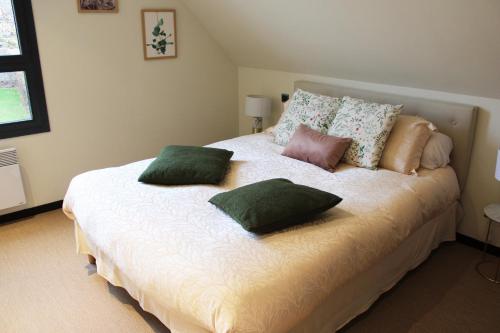 een slaapkamer met een bed met kussens erop bij Chez Pierrette à deux pas du Château de Meursault in Meursault