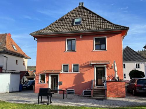 a large orange house with a black roof at Ferienwohnung Bett & Burg in Wertheim