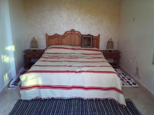 1 dormitorio con 1 cama grande con manta roja y blanca en Mesdunes en Azemmour