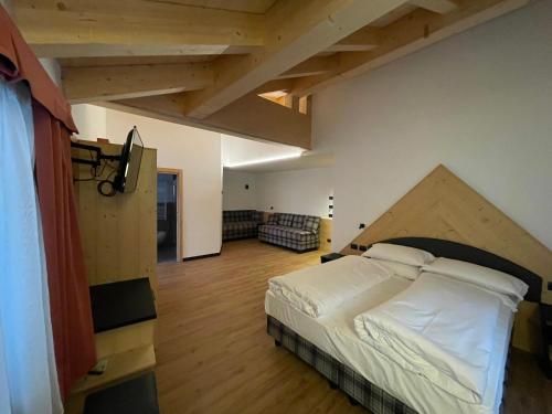 卡納澤伊的住宿－Albergo Garni Edy (B&B)，铺有木地板的客房设有一间带大床的卧室