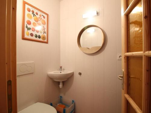 une salle de bain avec un lavabo, des toilettes et un miroir dans l'établissement Confortable T2 au centre de La Bourboule, à 100m des Thermes - FR-1-608-118, à La Bourboule