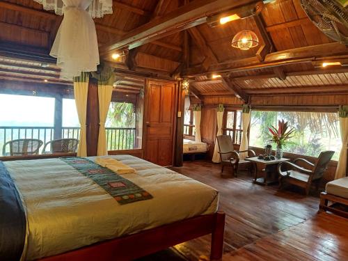 een slaapkamer met een bed en een tafel en stoelen bij Puluong Home in Pu Luong