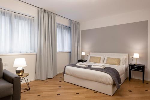 a bedroom with a bed and a couch and windows at Milan Royal Suites - Centro in Milan