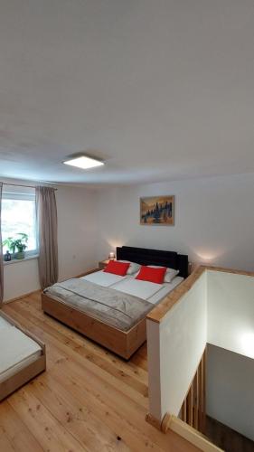 a bedroom with a large bed with red pillows at Apartments Ela in Rateče