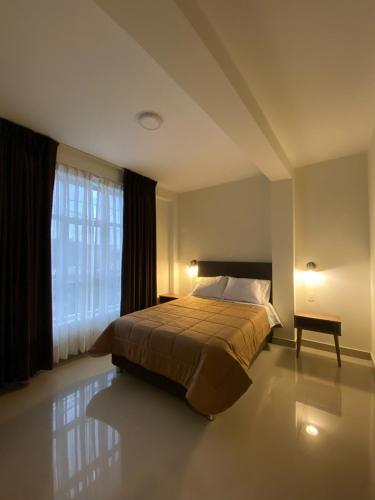 a bedroom with a bed and a large window at Hotel Alba in Ica
