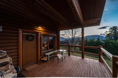 a porch of a cabin with a table and chairs at The Flysch in Miríki