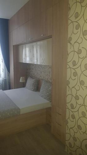 a bedroom with a bed with a wooden headboard at apartament Karla Indigo in Oradea