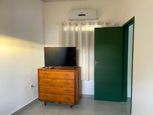 TV en un tocador en una habitación con puerta verde en Casa Pau Brasil, en Prado
