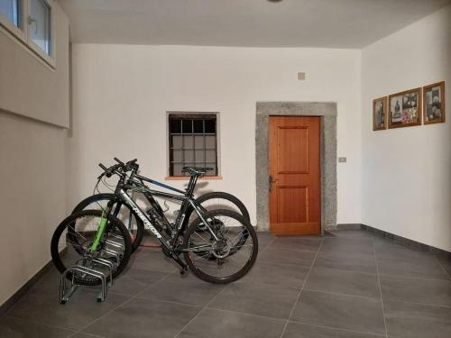 Una bicicleta estacionada en una habitación al lado de una puerta en Attico da Jenny, en Grosio
