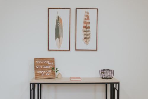 a console table with three pictures on the wall at Private Cottage - KING Beds, Brand New, Near Beach, Golfing, Shopping & Restaurants in Lake Worth