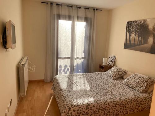 1 dormitorio con cama y ventana grande en Precioso apartamento en zona residencial, en Panticosa