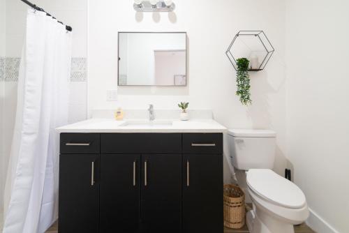 a bathroom with a sink and a toilet and a mirror at Private Cottage - KING Beds, Brand New, Near Beach, Golfing, Shopping & Restaurants in Lake Worth