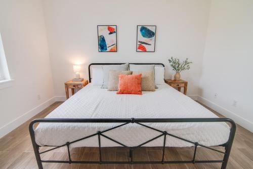 a bedroom with a bed with an orange pillow on it at Private Cottage - KING Beds, Brand New, Near Beach, Golfing, Shopping & Restaurants in Lake Worth