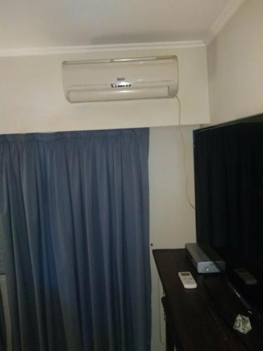 a room with a blue curtain and a desk and a heater at Dpto Hipólito Yrigoyen in Concordia