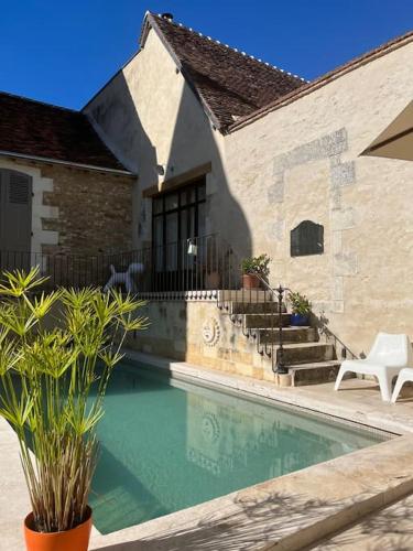 une maison avec une piscine à côté d'un bâtiment dans l'établissement Gîte des 3 Marchands, à Buzançais