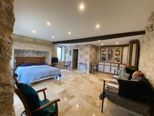 une chambre avec un lit et un salon dans l'établissement Maison de village, charme et confort, à Mauroux