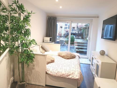 a bedroom with a bed and a large window at New COSY HOMES in Newhaven