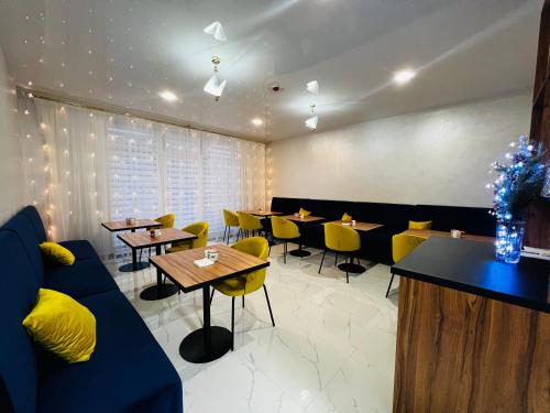 a dining room with tables and yellow chairs at Salut in Bukovel
