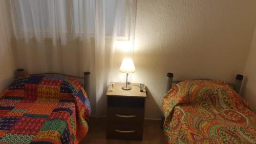 1 dormitorio con 2 camas y una lámpara en una mesa en Casa Alojamiento San Rafael en San Rafael