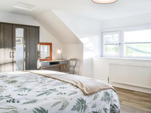 a white bedroom with a bed and a desk at Cowar Bothy in Haugh of Urr